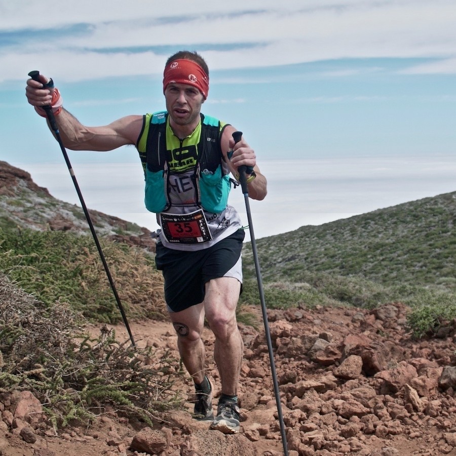 Pere Aurell climbing a steep mountain trail with poles