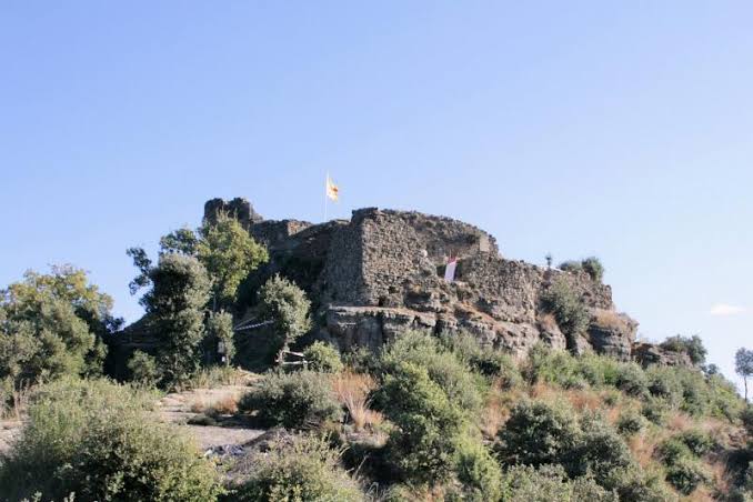 Ruins of the Castell d'Hostoles on a rocky outcrop above the valley