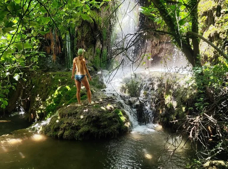 Swimmer on a moss-covered rock by the waterfall of the Gorg de Can Poetí